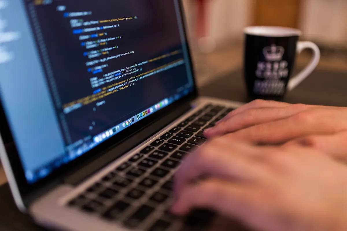 Les mains d’un développeur qui écrit du code sur un ordinateur portable